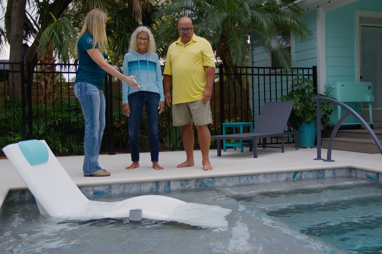 A family standing beside their completed custom pool and spa on handoff day